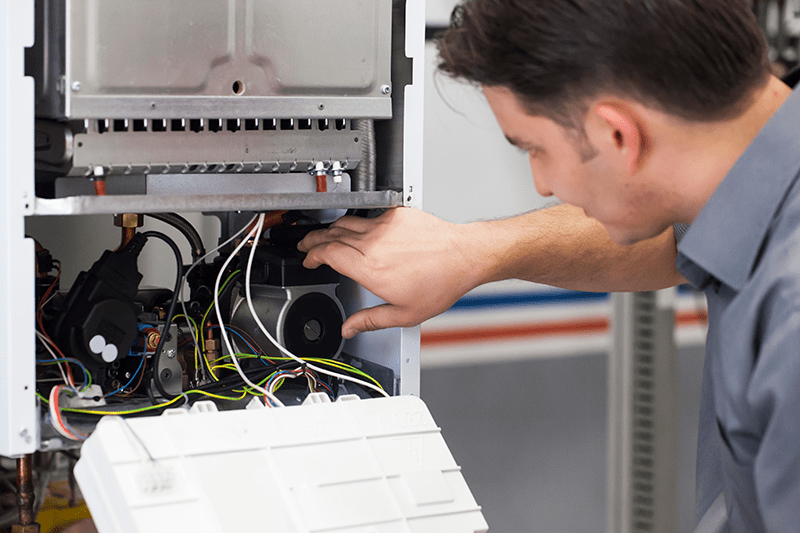 Image of someone working on a heat pump. 4 important heat pump maintenance tips.
