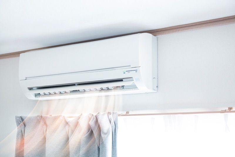 Planning to Remodel? Go Ductless! Image shows a ductless mini split on wall in home..